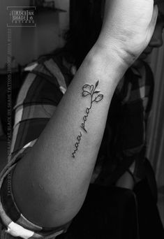 a black and white photo of a woman's arm with the word love tattooed on it