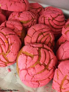 pink cookies with gold swirls are in a box