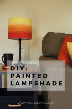 a lamp that is on top of a table next to a couch and coffee cup