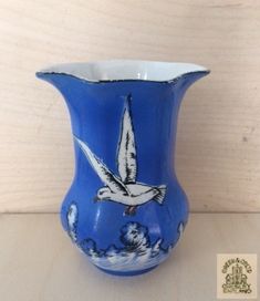 a blue vase with a bird painted on it