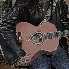 a woman sitting on a bench holding a guitar