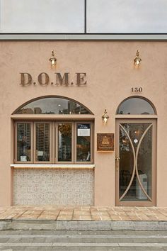 a store front with two windows and a clock on the side walk in front of it