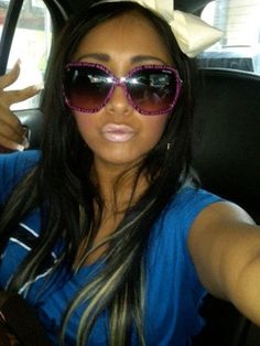 a woman wearing sunglasses sitting in the back seat of a car