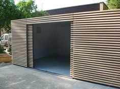 a large wooden building sitting on the side of a road next to a parking lot