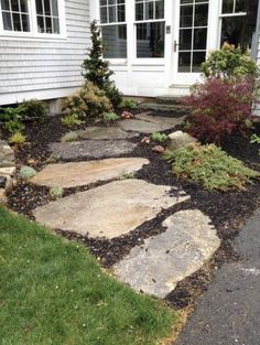 a stone walkway in front of a house