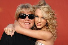 two women hugging each other in front of a red background