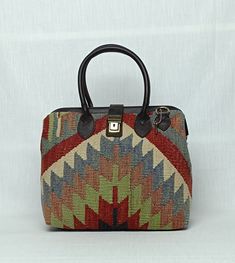 Welcome to AliDesignStore This  bag made of one of a kind Hand-sourced vintage Turkish Kilim Rug with supple cow leather. Suede-like interior. Measurements ; 30 cm x 27 cm x 15 cm  /   11,8''x10,6''x6''İnch Handle drop height : 12cm  /  4.7'' inch (All mesurements are Approximate ) Adjustable Shoulder Strap - Handcrafted - Materials : Vintage Turkish Kilim Rug                        Supple Cow Leather                       Brass Accessories                       Suede-like interior - Ships from a small business in Turkey Multicolor Travel Shoulder Bag With Handle Drop, Traditional Top Handle Satchel For Daily Use, Traditional Everyday Satchel With Top Carry Handle, Traditional Tote Satchel, Traditional Satchel For Everyday Use With Top Carry Handle, Traditional Tote Shoulder Bag With Top Handle, Vintage Laptop Bag With Leather Handles, Artisan Top Handle Bag For Daily Use, Artisan Satchel Bag With Handles