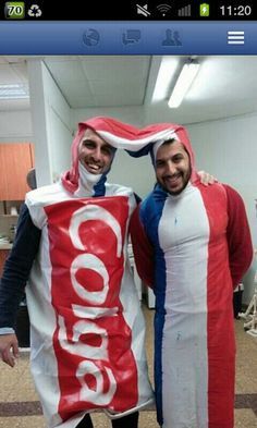 two men dressed up in costumes standing next to each other holding a bag of popcorn