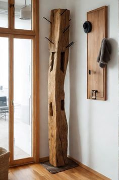 a large wooden sculpture sitting on top of a hard wood floor next to a window