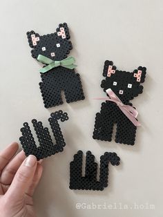 someone is holding three pieces of perler bead art that look like teddy bears