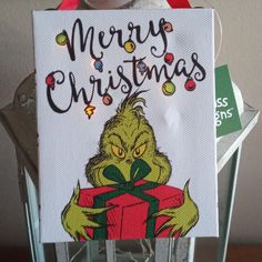 a christmas card with the grin face holding a present