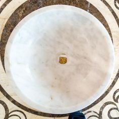 a person standing in front of a marble floor with a circular design on the ground