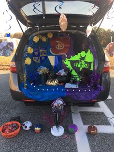 the back end of a car with decorations on it and other items in the trunk