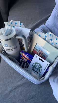 an open suitcase filled with personal items on top of a bed next to a pillow