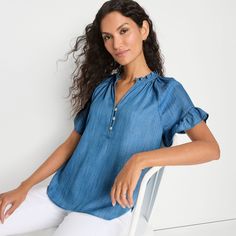 Here’s a playful touch to add to your wardrobe. Breezy ruffles and lightweight Tencel™ fabric make it a standout piece. The shirttail hem offers versatility for both tucked and untucked looks. A button front with a back panel ensures comfortable coverage. It drapes beautifully and is super soft to the touch for a luxurious feel, plus the certified compostable and biodegradable fiber is made using eco-conscious methods. Relaxed Fit Blouse With Ruffle Sleeves And Details, Ruffle Sleeve Blouse With Relaxed Fit, Blouse With Ruffle Sleeves And Relaxed Fit, Casual Tops With Ruffle Sleeves For Daywear, Chic Relaxed Fit Tops With Ruffles, Relaxed Fit Tops With Ruffles And Flutter Sleeves, Relaxed Fit Ruffle Sleeve Tops For Daywear, Casual Blouse With Ruffle Sleeve And Relaxed Fit, Relaxed Fit V-neck Ruffle Blouse