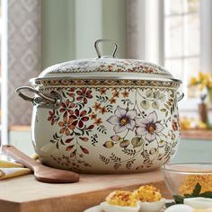 an ornately decorated casserole sits on a table with other dishes and utensils