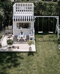 an aerial view of a small white house with a swing set in the back yard