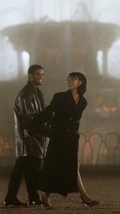 a man and woman are walking together in the foggy city with their arms around each other