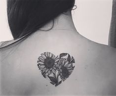 a woman with a heart shaped sunflower tattoo on her back