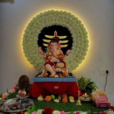 there is a statue of lord ganesh in the middle of flowers and other decorations