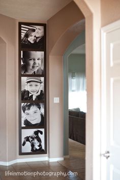 a family photo hanging on the wall in a hallway with tile flooring and beige walls