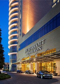 the front entrance to marriott asherron at night with cars parked outside