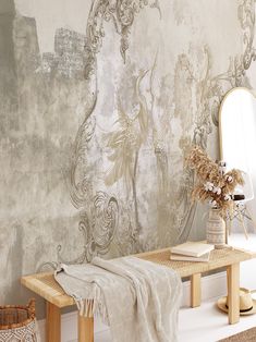 a room with a bench, mirror and wallpaper