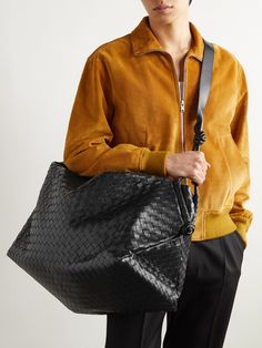 Bottega Veneta's holdall is a smart choice for weekend breaks or short-haul trips. It's been crafted from strips of leather, woven using the house's signature intrecciato technique, and has a spacious, canvas-lined interior that'll hold a change of clothes, laptop and grooming essentials. An internal snap-fastening pocket is ideal for securing smaller items, like your chargers. Designer Leather Duffle Bag For Shopping, Designer Woven Leather Travel Bag, Designer Travel Bag With Woven Leather, Black Travel Bag With Intrecciato Weave, Designer Leather Weekender Bag, Black Intrecciato Travel Bag, Designer Black Duffle Bag For Shopping, Designer Black Weekender Bag With Leather Handles, Designer Black Tote Weekender Bag