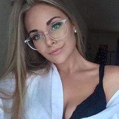 a woman wearing glasses is taking a selfie