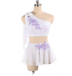 a white dress with purple flowers on the skirt and one shoulder, is shown in front of a mannequin