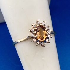 a ring with an orange and white diamond in it