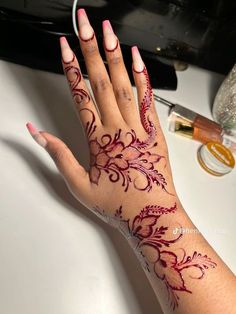 a woman's hand with henna tattoos on it