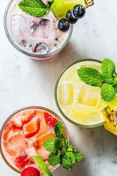 three glasses filled with different types of fruit and ices on top of a table