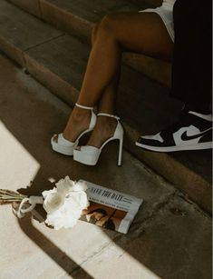 a bride's shoes and bouquet sitting on the steps