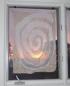 a white curtain hanging from the side of a window next to a window sill