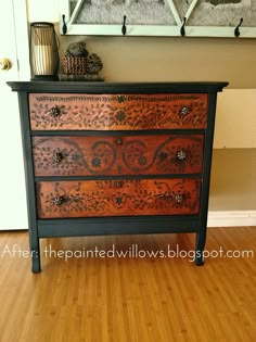 an old dresser is painted black and brown