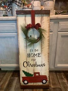 a wooden sign that says i'll be home for christmas with a red truck and wreath