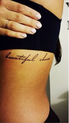 a woman's stomach with the words beautiful chaos written on her lower back side