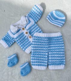 a blue and white knitted baby outfit with matching hat, booties and mittens