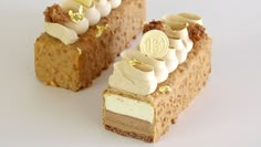 a piece of cake with white frosting and gold decorations on the top is cut in half