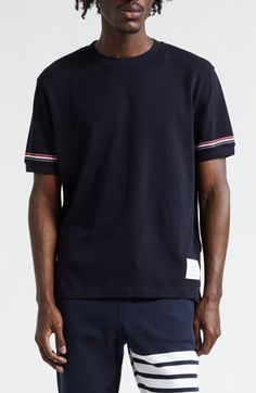 Thom Browne's varsity-stripe motif brings the label's signature refinement to a classic cotton T-shirt updated with a subtle high-low hem shut with buttons. 29" length (size 2) Crewneck Short sleeves High-low hem with button side vents 100% cotton with 97% cotton, 3% elastane trim Dry clean or machine wash, tumble dry Made in Italy Designer Clothing Sporty Cotton T-shirt With Ribbed Cuffs, Navy Sporty Top With Contrast Stripes, Sporty Signature Stripes Tops For College, Casual Short Sleeve Tops With Signature Stripes, Classic Striped Tops With Ribbed Cuffs, Casual Tops With Striped Cuffs And Relaxed Fit, Sporty Tops With Striped Hem And Relaxed Fit, Sporty Relaxed Fit Top With Striped Hem, Casual Relaxed Fit Top With Striped Cuffs