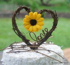 a cake with a sunflower in the shape of a heart on top of it