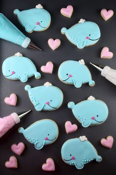 decorated cookies in the shape of elephants and hearts with icing cutters next to them