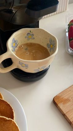 a bowl of chocolate and some pancakes on a table