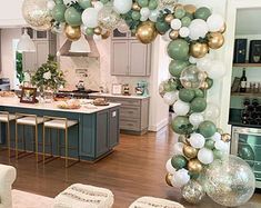 a living room filled with furniture and balloons in the shape of an arch on top of a kitchen island