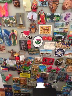 a refrigerator covered in magnets and pictures next to a wall mounted on it's side