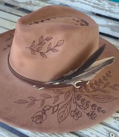 "Personalize it with your own name or phrase! 🤠\"WHISPY WILDFLOWERS\" -Pictured hat is: *MATERIAL - Felt *COLOR - Camel *STYLE - Peach Top Rancher -Listing is for this specific hat design. Message me for color and style choices that are currently available for this design. -Each unique, one-of-a-kind design is imagined, drawn and burned by Vicki at FanciiPants. I don't use stencils, projectors or stamps. -Listing is for hat only. A basic hatband, of sellers choice, is included as a FREE bonus! Your hat may or may not include the exact band shown in pictures. Hat band and feathers are removable so you can customize with your own unique hatband and decor if you'd like. Bands and/or feathers may shift or fall off during shipping. -\"One Size Fits Most\" with adjustable drawstring. 🤠 MESSAGE Burned Felt Hat, Burnt Hat, Boho Cowgirl Style