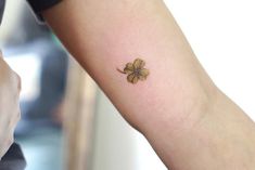 a small four leaf clover tattoo on the arm