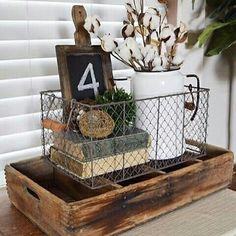 a wooden tray with a sign and some plants in it on top of a table