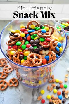 a glass bowl filled with cereal and pretzels